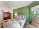 Bedroom showcasing green walls, wood furniture, and a comfortable seating area near the window at 1258 Donalds Pl, The Villages, FL 32162