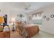 Bedroom with a ceiling fan, carpeted floors, and a metal headboard with wall decor at 1258 Donalds Pl, The Villages, FL 32162