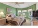 Bedroom with green walls, ceiling fan, bay window, and neutral carpeting at 1258 Donalds Pl, The Villages, FL 32162