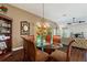 Dining room with glass table, wood chairs, wood floors and display cabinet at 1258 Donalds Pl, The Villages, FL 32162