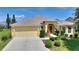 Charming single-story home featuring a two-car garage, well-manicured lawn, and inviting entryway at 1258 Donalds Pl, The Villages, FL 32162