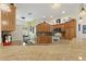 Open-concept kitchen featuring granite countertops, wood cabinets, and a breakfast bar overlooking the dining area at 1258 Donalds Pl, The Villages, FL 32162