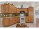 Functional kitchen featuring wood cabinetry, mosaic tile backsplash, and a view to the dining area at 1258 Donalds Pl, The Villages, FL 32162