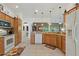 Spacious kitchen with wood cabinets, granite countertops, and views to the dining and living areas at 1258 Donalds Pl, The Villages, FL 32162