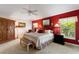 The main bedroom has a red accent wall, ceiling fan, and ample natural light at 1258 Donalds Pl, The Villages, FL 32162