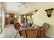 Covered patio area with ceiling fan, outdoor kitchen and grill, and a wicker table set for outdoor dining at 1258 Donalds Pl, The Villages, FL 32162