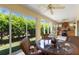 Outdoor patio area with ceiling fan, outdoor kitchen, wicker table set and sliding glass doors to the yard at 1258 Donalds Pl, The Villages, FL 32162