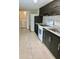Galley kitchen with modern dark wood cabinetry, light countertops, and white appliances at 1309 N Thacker Ave, Kissimmee, FL 34741
