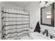 Well-lit bathroom with a decorative shower curtain, vanity, and a modern sink at 1408 Polk City Rd, Haines City, FL 33844