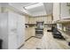 Bright kitchen featuring white appliances, granite countertops, and ample cabinet space at 1408 Polk City Rd, Haines City, FL 33844