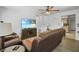 Cozy living room features a leather sofa, ceiling fan, and a large flat-screen television at 1408 Polk City Rd, Haines City, FL 33844