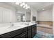 Bright bathroom featuring dual sinks, a soaking tub, and a large mirror at 152 Whirlaway Dr, Davenport, FL 33837