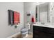 Cozy bathroom featuring a dark vanity, toilet, and a mirror at 152 Whirlaway Dr, Davenport, FL 33837