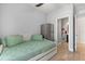 Neutral bedroom featuring a twin bed, mini fridge, and bathroom access at 152 Whirlaway Dr, Davenport, FL 33837