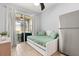 Bright bedroom with a bed and a mini fridge, featuring sliding doors to the patio at 152 Whirlaway Dr, Davenport, FL 33837