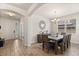 Open dining area featuring wood floors, a modern chandelier, and a decorative mirror at 152 Whirlaway Dr, Davenport, FL 33837