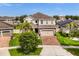 Beautiful home showcases a well-manicured lawn and brick driveway leading to a two-car garage at 152 Whirlaway Dr, Davenport, FL 33837