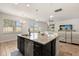 Kitchen island with bar stool seating, granite countertop, and stainless steel dishwasher. Open concept to living area at 152 Whirlaway Dr, Davenport, FL 33837