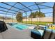 Screened-in pool and patio area with outdoor seating and landscaping at 152 Whirlaway Dr, Davenport, FL 33837