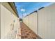 Tiled side yard between two properties, with white fence and manicured gravel and shrubs at 1602 Steely Dr, Dundee, FL 33838
