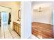 Interior shot looking at the bathroom with double vanity and wood flooring in the living space at 1784 Sparkling Water Cir, Ocoee, FL 34761