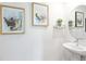 Chic powder room with a pedestal sink, modern faucet, decorative wall art, and stylish design at 185 E Warren Ave, Longwood, FL 32750