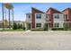 Modern townhouse exterior with well-maintained landscaping, set against a bright sky and urban backdrop at 185 E Warren Ave, Longwood, FL 32750