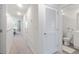 Hallway leading to bathroom and bedroom areas, featuring neutral colored walls and carpets at 185 E Warren Ave, Longwood, FL 32750