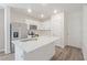 Modern kitchen with white cabinets, stainless steel appliances, and a stylish center island at 185 E Warren Ave, Longwood, FL 32750