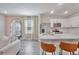 Bright kitchen featuring a stainless steel refrigerator, white cabinets, and stylish bar seating at 185 E Warren Ave, Longwood, FL 32750