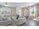 Bright living room featuring a large sectional sofa, modern flooring, and natural light from the window at 185 E Warren Ave, Longwood, FL 32750