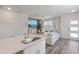 Bright open-concept living space featuring modern kitchen, comfortable seating, and a stylish front door at 185 E Warren Ave, Longwood, FL 32750