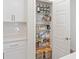 Organized pantry with white shelving, ample storage space, and stylish containers for efficient organization at 185 E Warren Ave, Longwood, FL 32750