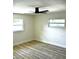 Move-in-ready bedroom featuring stylish wood-look floors, two windows and a ceiling fan for natural light and comfort at 2074 Dunsford Dr, Orlando, FL 32808