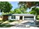 Charming single-story home with a brick accent, dark garage door, and lush landscaping at 2074 Dunsford Dr, Orlando, FL 32808