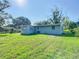 View of the back exterior of the home with grassy yard at 220 Hillside Dr, Lakeland, FL 33803