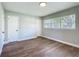 A bedroom features wood flooring, multiple doors, and a window at 220 Hillside Dr, Lakeland, FL 33803