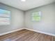 This is a bedroom with two windows and wood-look floors at 220 Hillside Dr, Lakeland, FL 33803