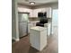 Well-lit kitchen includes white cabinetry, stainless appliances, and functional island space for cooking at 220 Hillside Dr, Lakeland, FL 33803