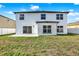 The house has a bright, white exterior with sliding glass doors and multiple windows facing the backyard at 242 Anson Dr, Kissimmee, FL 34758