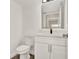 Modern half-bath featuring a sleek vanity with an LED mirror and a toilet at 242 Anson Dr, Kissimmee, FL 34758