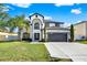 Stunning two-story home featuring a black-trimmed, white exterior, lush lawn, and ample driveway space at 242 Anson Dr, Kissimmee, FL 34758