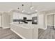 Bright kitchen featuring quartz countertops, white cabinetry, stainless steel appliances and modern pendant lighting at 242 Anson Dr, Kissimmee, FL 34758