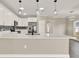 Bright kitchen featuring quartz countertops, white cabinetry, stainless steel appliances and modern pendant lighting at 242 Anson Dr, Kissimmee, FL 34758