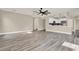 Open-concept living space with gray wood-look flooring, crown molding, and seamless flow to the kitchen area at 242 Anson Dr, Kissimmee, FL 34758