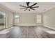 Bright living room featuring wood floors, large windows, ceiling fan, and backyard access at 242 Anson Dr, Kissimmee, FL 34758