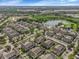 Aerial view of many townhomes, pond with fountain, and green space at 2614 Lodi Cir # 106, Kissimmee, FL 34746
