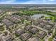 Aerial view of many townhomes, pond with fountain, and green space at 2614 Lodi Cir # 106, Kissimmee, FL 34746