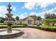 Exterior shot of a clubhouse featuring a fountain, well-maintained landscaping, and ample parking at 2614 Lodi Cir # 106, Kissimmee, FL 34746