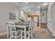 Cozy dining area with a wooden table and white chairs, flowing into a kitchen area and staircase at 2614 Lodi Cir # 106, Kissimmee, FL 34746